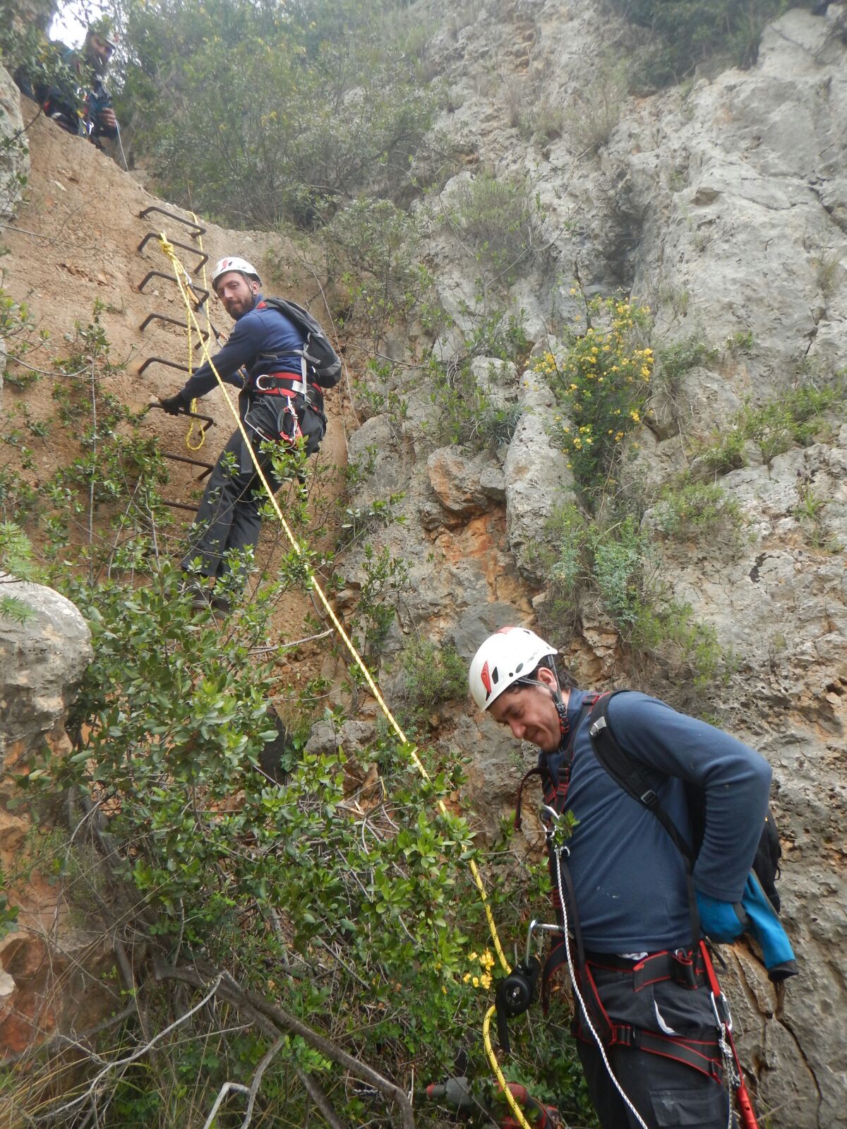 Tecnici scalatori riparano una perdita lungo una parete rocciosa