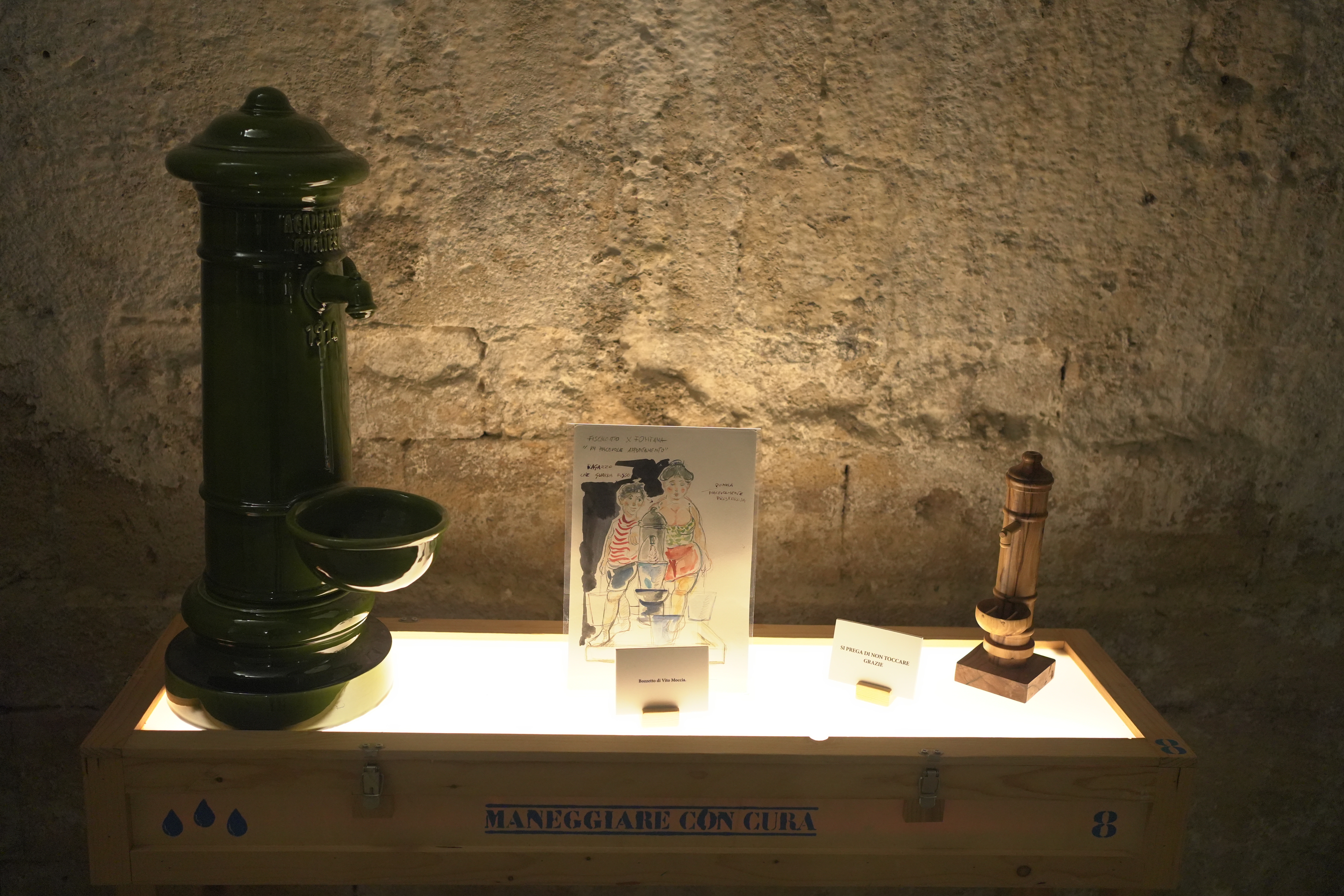 Una teca con su una fontana verde in ferro e una più piccola in legno.