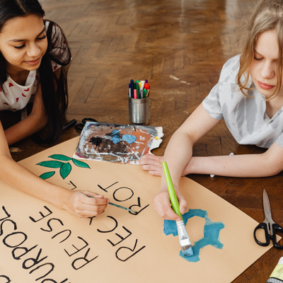 foto di bambini mentre disegnano e colorano un cartellone 