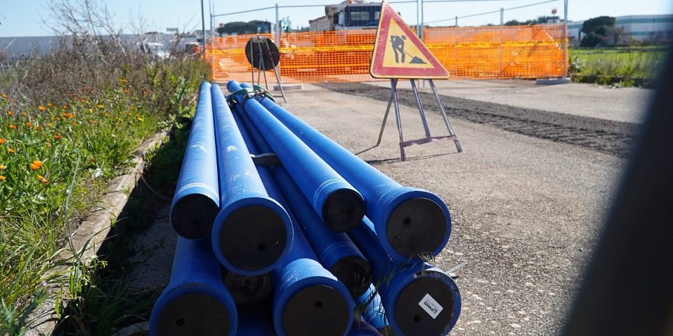 immagine di tubi disposti sull'asfalto in un cantiere